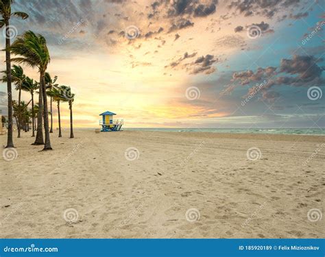 Dramatic Sunrise On The Beach With Palm Trees And Lifeguard Tower Stock