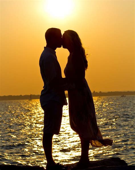 kissing by the waterfront sunset | Wedding engagement pictures, Beach engagement, Romantic images