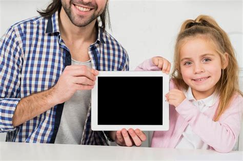 Padre E Hija Enseñando Tablet Foto Gratis