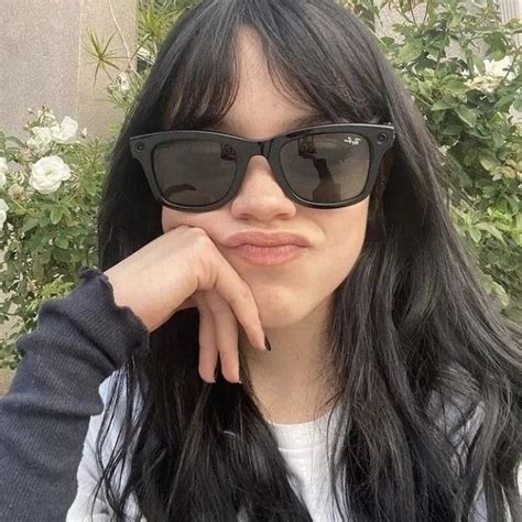 A Close Up Of A Person Wearing Sunglasses With Flowers In The Backgroung