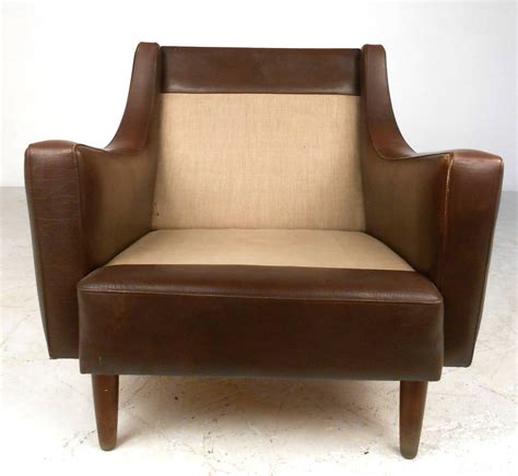 A leather pouf works in place of an ottoman and more easily doubles as spare seating for unexpected guests. Mid-Century Modern Tufted Brown Leather Club Chair at 1stdibs