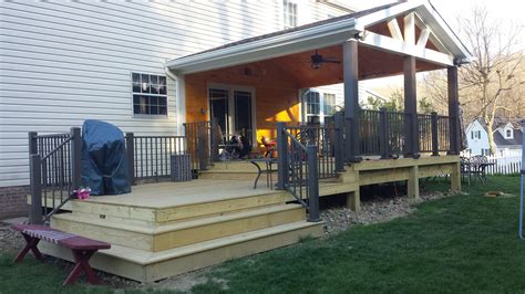 Rustic Open Concept Wood Deck With Metal Railings And A Gable Roof