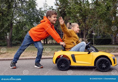 Cute Boy Pushing Children S Car With Little Girl Outdoors Stock Photo