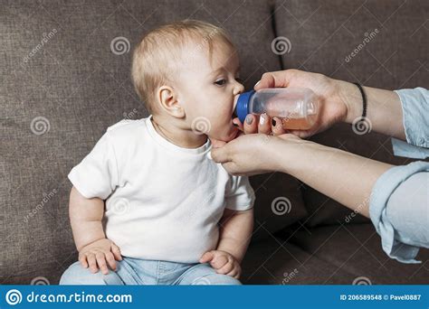 Lovely Mother Giving Her Baby Drink Juice From Bottle Stock Photo