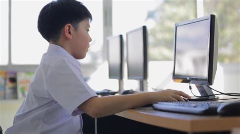 Happy Asian child using a desktop computer at school . Stock Video Footage - Storyblocks