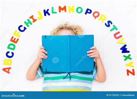 Kind Das Buchstaben Des Alphabetes Und Des Ablesens Lernt Stockfoto