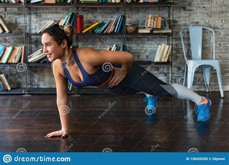 Young Fitness Woman Doing Push Ups Workout On One Arm On Floor At Home