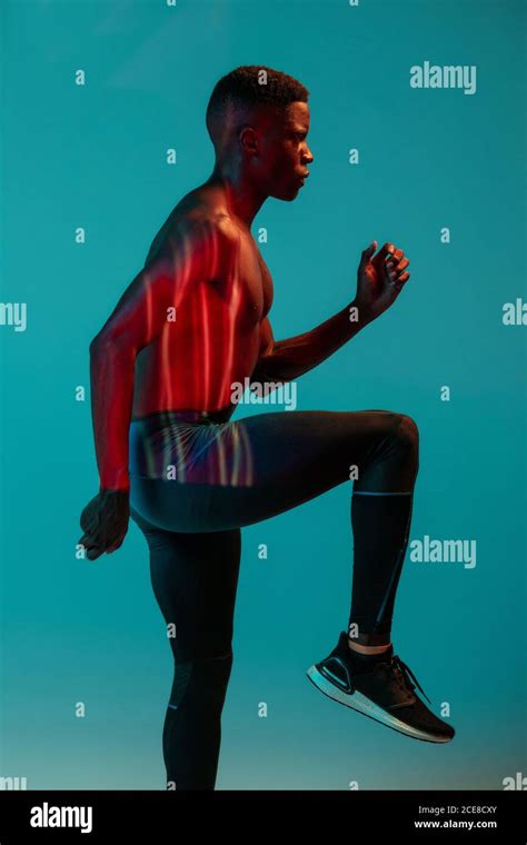 Full Body Side View Of Young African American Male Runner In Colorful