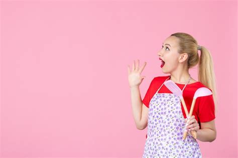 Free Photo Front View Young Housewife Holding Cutlery On Pink Wall