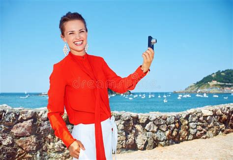 Happy Woman Taking Photo With Digital Camera In Front Of Lagoon Stock