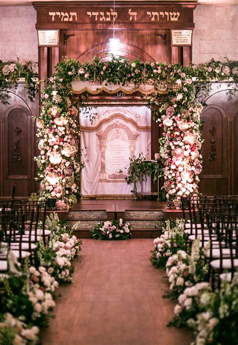 Chuppah covered in florals and florals lining the aisle by Layers of Lovely Floral Design ...