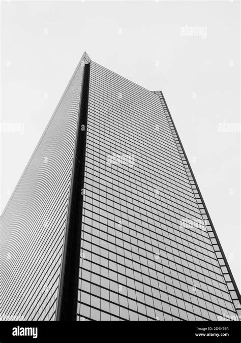 Vertical Low Angle Shot Of A Modern Office Building In Grayscale Stock