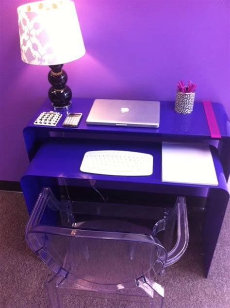 A Purple Desk With A Laptop On It And A Lamp Next To It In Front Of A