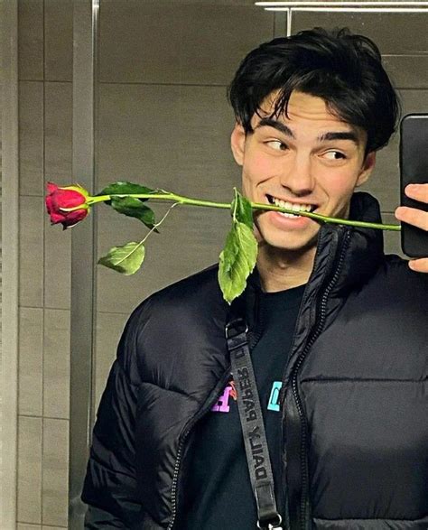 A Man Taking A Selfie With A Rose In His Mouth