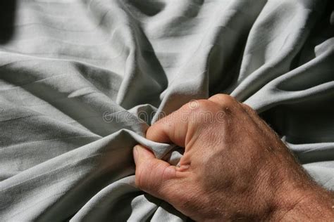 An Older Mans Hand Is Holding The Edge Of His Bed Sheet