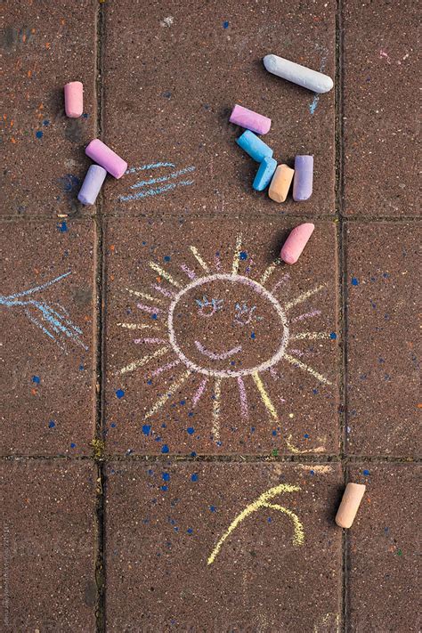 Child Chalk Drawing Of A Sun On A Pavement Del Colaborador De Stocksy
