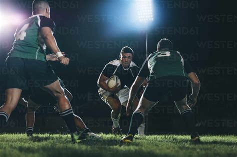 Rugby Player Running On Field With Ball And Tackling With Opposite Team