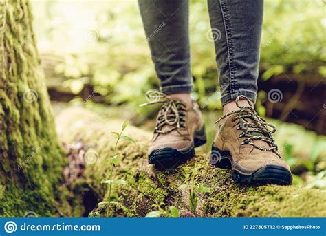 Close Up Of Hiker Feet And Hiking Boots On Wood Log In Forest Stock