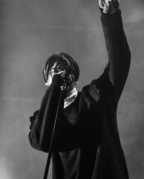 Black And White Photograph Of A Person Holding A Microphone Up In The