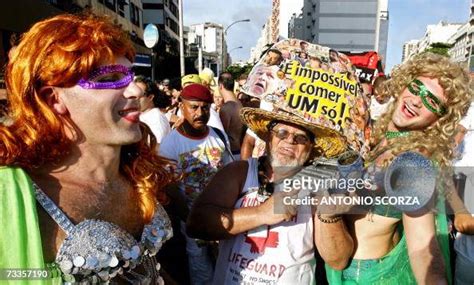Brazilian Drag Queens Pose Next To A Samba Player During The