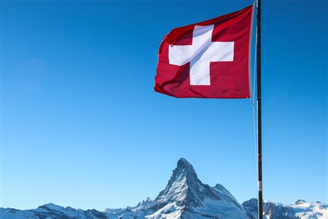 Bandiera de la svizra) displays a white cross in the centre of a square red field. Free Stock Photo of Swiss Flag Over Matterhorn Mountain Peak