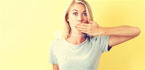 Young Woman Covering Her Mouth On A Blue Background Royalty Free Stock