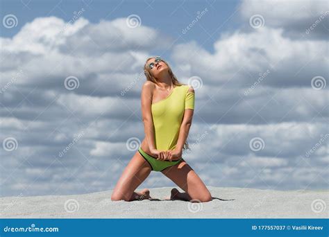 Seductive Woman In Stylish Swimsuit Kneeling In Sand Stock Image