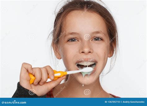 Portrait Of An Eight Year Old Girl Who Brushes Her Teeth With A