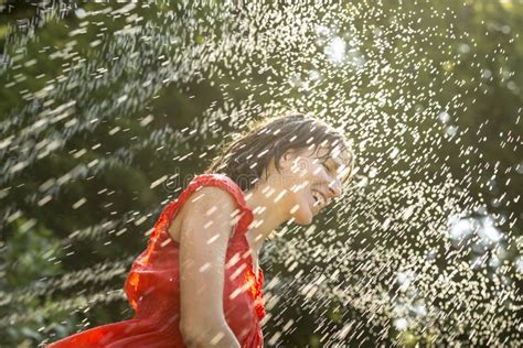 laughing woman cooling off under a spray of water stock image image of enjoyment dress 55296771