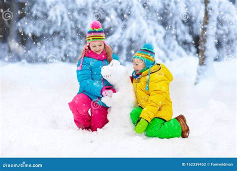 Kids Making Winter Snowman Children Play In Snow Stock Photo Image