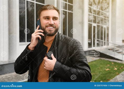 Handsome Man In Stylish Leather Jacket Talking On Mobile Phone Outdoors