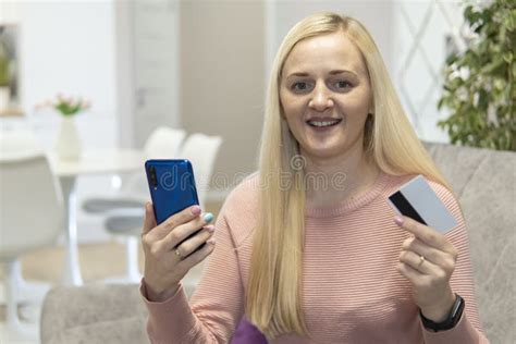Blonde Girl Sit On The Couch With Phone And Credit Card Concept Online Shopping Stock Image