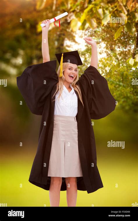 Composite Image Of Blonde Student In Graduate Robe Holding Up Her