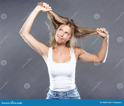 Beautiful Young Woman Pulling Her Hair Over Gray Background Stock