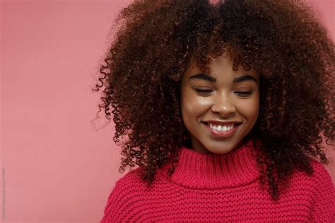 Portrait Of A Young African American Afro Woman In Pink Studio Smiling