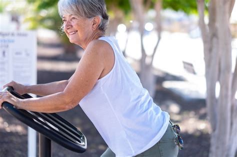 Premium Photo Smiling Senior Woman Exercising At Outdoors Gym Playground Equipment