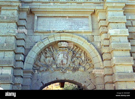 A sculpted coat of arms and inscription above the arched gateway to the