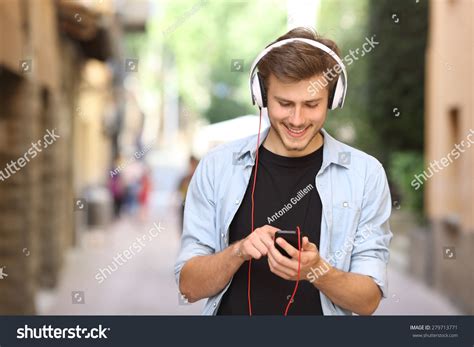 Happy Guy Walking And Using A Smart Phone To Listen Music With