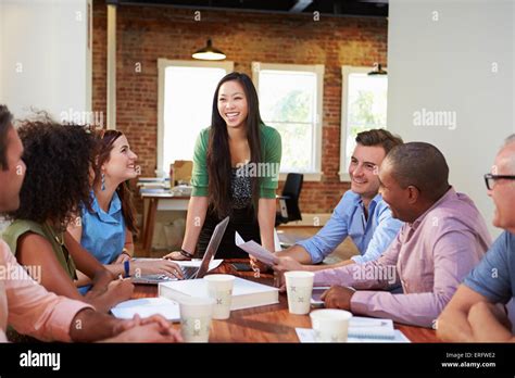Female Boss Addressing Office Workers At Meeting Stock Photo Alamy