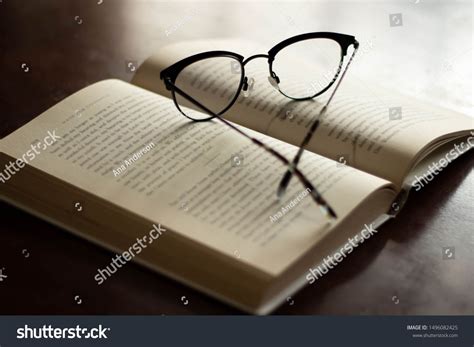 Open Book With Reading Glasses Next To Window With Light Coming In