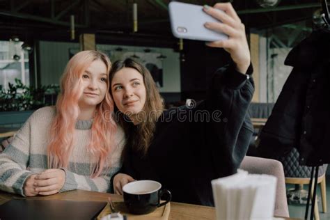 Cheerful Young Lesbian Couple Selfie Using Mobile Phone At A Coffee Shop Two Joyful Attractive