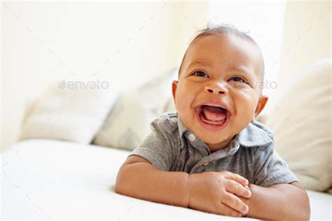 Laughing Baby Boy Lying On Tummy At Home Stock Photo By Monkeybusiness