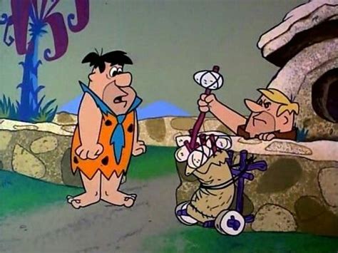 Two Cartoon Characters Are Standing In Front Of A Rock Cave And One Is