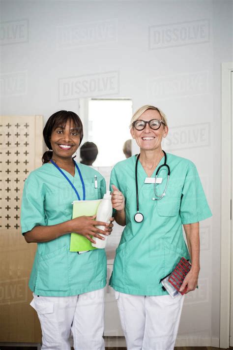 Portrait Of Smiling Female Healthcare Workers Standing In Clinic
