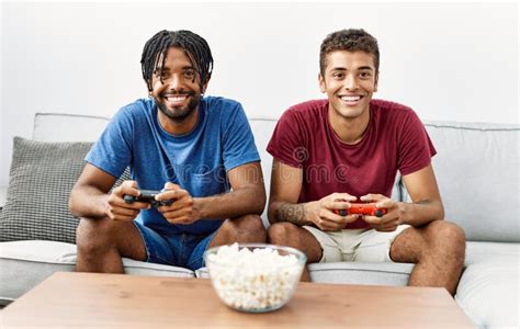Two Men Friends Playing Video Game Sitting On Sofa At Home Stock Image