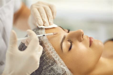 Cosmetologist Making Facial Beauty Injection To Young Woman In Beauty