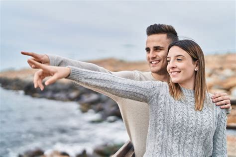 man and woman couple hugging each other pointing with finger at seaside stock image image of