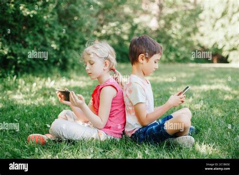 Niño Y Niña Jugar Juegos En Smartphones Al Aire Libre Adicción A La