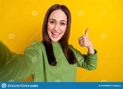 Self Portrait Of Attractive Cheerful Woman Showing Thumbup Isolated Over Bright Yellow Color