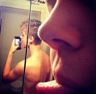 A Man Taking A Selfie In Front Of A Mirror With His Tongue Hanging Out